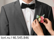 Молодая женщина прикалывает бутоньерку к костюму для выпускного, крупным планом. Стоковое фото, фотограф Pixel_shot / Фотобанк Лори