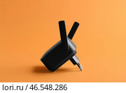Черный повторитель Wi-Fi на оранжевом фоне. Стоковое фото, фотограф Pixel_shot / Фотобанк Лори