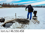 Farmer mines sapropel freshwater sediments by pulling basket of lake muck through ice, he then transports nutrient-rich goop on sled for agriculture. Стоковое фото, фотограф Владимир Григорьев / Фотобанк Лори