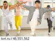 Young man standing performs basic hip hop movements in front of group of students. Стоковое фото, фотограф Яков Филимонов / Фотобанк Лори