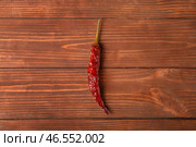 Сушеный жгучий перец на коричневом деревянном фоне. Стоковое фото, фотограф Pixel_shot / Фотобанк Лори