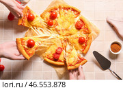 Женщины берут кусочки вкусной пиццы маргарита на бежевом кафельном столе. Стоковое фото, фотограф Pixel_shot / Фотобанк Лори