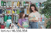 Mother and daughter choose a festive set of care cosmetics and shower accessories in the household department of the supermarket. Woman with child holding packaged shower gels and shampoos. Стоковое видео, видеограф Яков Филимонов / Фотобанк Лори