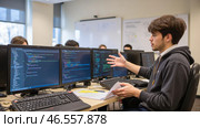 Young developer in office reacting to complex code on multiple monitors. Confused programmer analyzing software, debugging errors, working on project, discussing IT issues. Software development. Стоковое AI-изображение, AI-художник Павел Муравьев / Фотобанк Лори