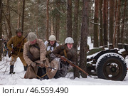 Sestroretsk, Russia - February 19, 2023: in a snowy forest, soldiers reenact a WWII winter battle, highlighting military tactics and teamwork in historical restoration. Редакционное фото, фотограф Aleksandr Golubev / Фотобанк Лори