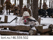 Sestroretsk, Russia - February 19, 2023: In a snowy forest, soldiers in winter gear meticulously recreate WWII battle tactics and equipment. Редакционное фото, фотограф Aleksandr Golubev / Фотобанк Лори