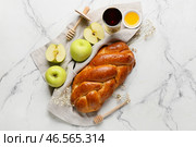Мед с яблоками, халой и сакраментальным кубком вина на белом фоне. Празднование Рош ха-Шана (еврейский Новый год) Стоковое фото, фотограф Pixel_shot / Фотобанк Лори