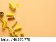 Катушки с нитками, шариковый штифт и измерительная лента на цветном фоне. Стоковое фото, фотограф Pixel_shot / Фотобанк Лори