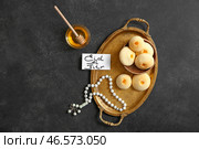 Поднос с вкусным арабским печеньем, медом и поздравительной открыткой для Ид аль-Фитр (Праздник разговения) на темном фоне. Стоковое фото, фотограф Pixel_shot / Фотобанк Лори