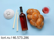 Традиционный хлеб халы с вином, свечами и еврейской кепкой на цветном фоне. Шаббат Шалом. Стоковое фото, фотограф Pixel_shot / Фотобанк Лори