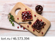 Тосты с вкусным брусничным вареньем на светлом деревянном фоне. Стоковое фото, фотограф Pixel_shot / Фотобанк Лори