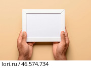 Человек держит пустую фоторамку на бежевом фоне. Стоковое фото, фотограф Pixel_shot / Фотобанк Лори