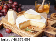 Деревянная доска с вкусным сыром Камамбер на столе. Стоковое фото, фотограф Pixel_shot / Фотобанк Лори