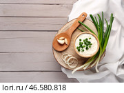 Миска вкусной сметаны с нарезанным луком-пореем и луком на сером деревянном фоне. Стоковое фото, фотограф Pixel_shot / Фотобанк Лори