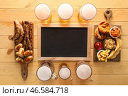 Стаканы холодного пива, пустая доска, доски с баварскими сосисками и закусками на деревянном фоне. Октоберфест. Стоковое фото, фотограф Pixel_shot / Фотобанк Лори