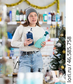 Woman buying cleaning sprays on Christmas tree background. Стоковое фото, фотограф Яков Филимонов / Фотобанк Лори