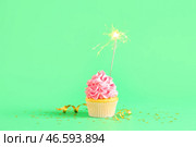 Сладкий праздничный капкейк с бенгальским огнём на зелёном фоне. Стоковое фото, фотограф Pixel_shot / Фотобанк Лори