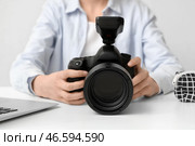 Фотограф-женщина с профессиональной фотокамерой, сидящая за световым столом. Стоковое фото, фотограф Pixel_shot / Фотобанк Лори