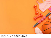 Спортивное оборудование с массажным роликом для тела и баскетбольным мячом на оранжевом фоне. Вид сверху. Стоковое фото, фотограф Pixel_shot / Фотобанк Лори