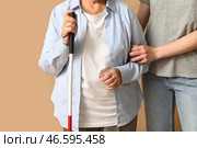 Молодая женщина с незрячей бабушкой на бежевом фоне, крупный план. Стоковое фото, фотограф Pixel_shot / Фотобанк Лори