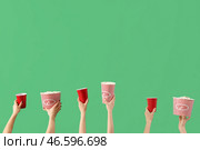 Руки, держащие ведра с попкорном и напитками на зеленом фоне. Стоковое фото, фотограф Pixel_shot / Фотобанк Лори