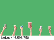 Руки, держащие ведра с попкорном и напитками на зеленом фоне. Стоковое фото, фотограф Pixel_shot / Фотобанк Лори