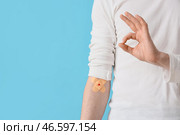 Мужчина-донор крови с наложенными пластырями, на фоне синего цвета, крупный план. Стоковое фото, фотограф Pixel_shot / Фотобанк Лори