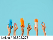 Солнцезащитный крем и буквы SPF в женских руках на синем фоне. Стоковое фото, фотограф Pixel_shot / Фотобанк Лори