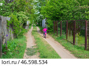 Девочка едет на велосипеде по просёлочной дороге, весна за городом. Волгоградская область, Городищенский район, Россия. (2020 год). Редакционное фото, фотограф Андрей Цыганков / Фотобанк Лори