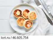 Тарелка с вкусными сырниками на светлом деревянном фоне. Стоковое фото, фотограф Pixel_shot / Фотобанк Лори