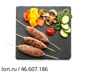 Доска шампуров с вкусным люля-кебабом и овощами на белом фоне. Стоковое фото, фотограф Pixel_shot / Фотобанк Лори