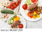 Тарелки шашлыка с вкусным люля-кебабом и овощами на светлом фоне. Стоковое фото, фотограф Pixel_shot / Фотобанк Лори