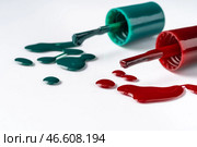 Bright colored nail polish bottles with drippings on white background. Стоковое фото, фотограф Сергей Толмачёв / Фотобанк Лори