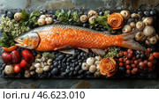 An exquisite composition with fish, vegetables, mushrooms and decorative elements, stylized as gastronomic art. In the center is a large fish with bright orange-gold scales, reminiscent of carp or trout. It is laid out against a background of black stones, which creates a contrast and enhances its color. Around the fish are mushrooms, red and yellow tomatoes, grapes, greenery, as well as decorations in the form of roses made of vegetables. The atmosphere of the image is luxurious and aesthetically thought out, with a touch of culinary art. Стоковое AI-изображение, AI-художник Анна Кривицкая / Фотобанк Лори