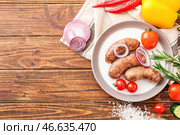 Тарелка с вкусными жареными колбасками и овощами на столе. Стоковое фото, фотограф Pixel_shot / Фотобанк Лори