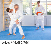 Judo or jiu jitsu classes - two men of different age practicing grabbing and throwing on sports mats. Стоковое фото, фотограф Яков Филимонов / Фотобанк Лори