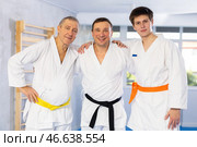 Three generations of martial arts fighters friendly embracing in training room. Стоковое фото, фотограф Яков Филимонов / Фотобанк Лори