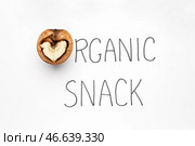 Вкусный орех с текстом ОРГАНИЧЕСКИЙ СНЕК на белом фоне. Стоковое фото, фотограф Pixel_shot / Фотобанк Лори