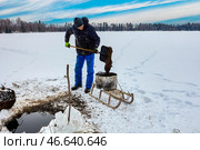 Organic fertilizer is derived as farmer extracts lake sapropel through ice, filling tank with lacustrine mud, delivering it to rural fields via sled. Стоковое фото, фотограф Владимир Григорьев / Фотобанк Лори