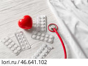 Стетоскоп, форма доктора, сердце и пилюльки на деревянной предпосылке. Кардиологическая концепция. Стоковое фото, фотограф Pixel_shot / Фотобанк Лори