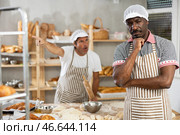 Disheartened African artisan baker scolded by partner in bakery. Стоковое фото, фотограф Яков Филимонов / Фотобанк Лори