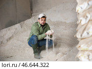 Livestock breeder checking quality of maize meal in farm storage. Стоковое фото, фотограф Яков Филимонов / Фотобанк Лори