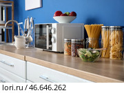 Микроволновая печь и продукты на современной кухне. Стоковое фото, фотограф Pixel_shot / Фотобанк Лори