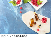 Бутылки эфирного масла малины на цветном фоне. Стоковое фото, фотограф Pixel_shot / Фотобанк Лори