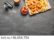 Вкусные луковые кольца с картофелем фри и соусом на сером фоне. Стоковое фото, фотограф Pixel_shot / Фотобанк Лори