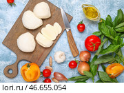 Разделочная доска с сыром моцарелла, маслом и овощами на цветном фоне. Стоковое фото, фотограф Pixel_shot / Фотобанк Лори