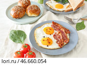 Композиция с вкусной яичницей, беконом и булочками на столе. Стоковое фото, фотограф Pixel_shot / Фотобанк Лори