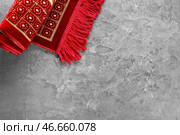 Мусульманский молитвенный коврик на сером фоне. Стоковое фото, фотограф Pixel_shot / Фотобанк Лори