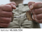 Наручники на руках арестованного преступника. Стоковое фото, фотограф Сергей Булкин/NEWS.ru / ТАСС / Фотобанк Лори
