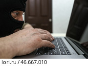 Киберпреступник в черной балаклаве. Стоковое фото, фотограф Сергей Булкин/NEWS.ru / ТАСС / Фотобанк Лори
